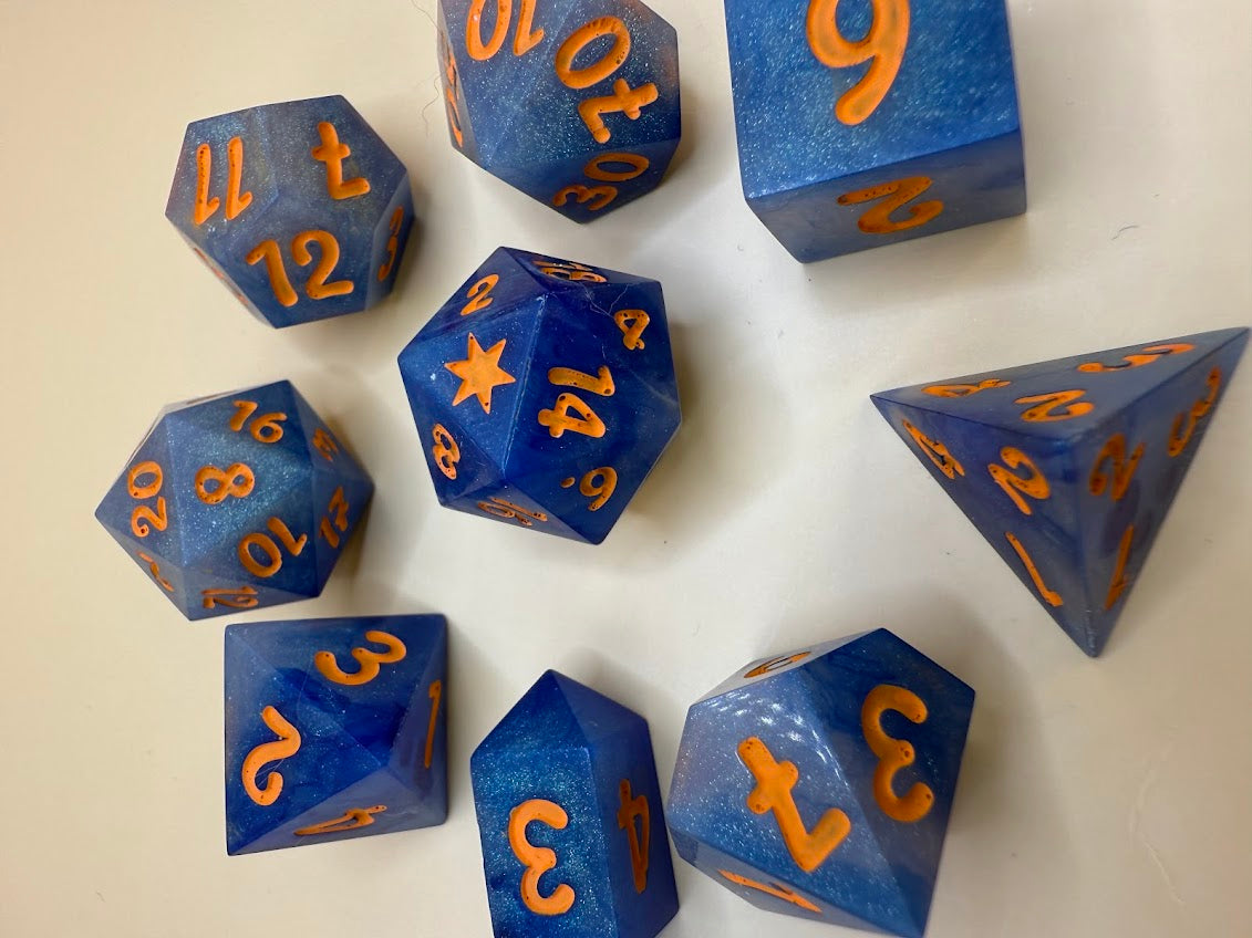 Blue polyhedral dice with orange numbers on a beige background