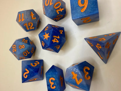 Blue polyhedral dice with orange numbers on a beige background