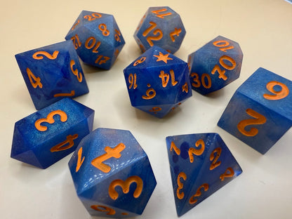 Blue polyhedral dice with orange numbers on a white background