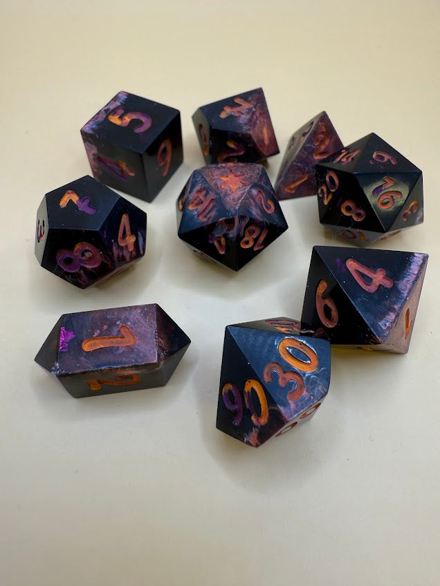 Set of polyhedral dice with purple and orange numbers on a white background
