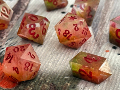 Set of polyhedral dice with red numbers on a textured surface