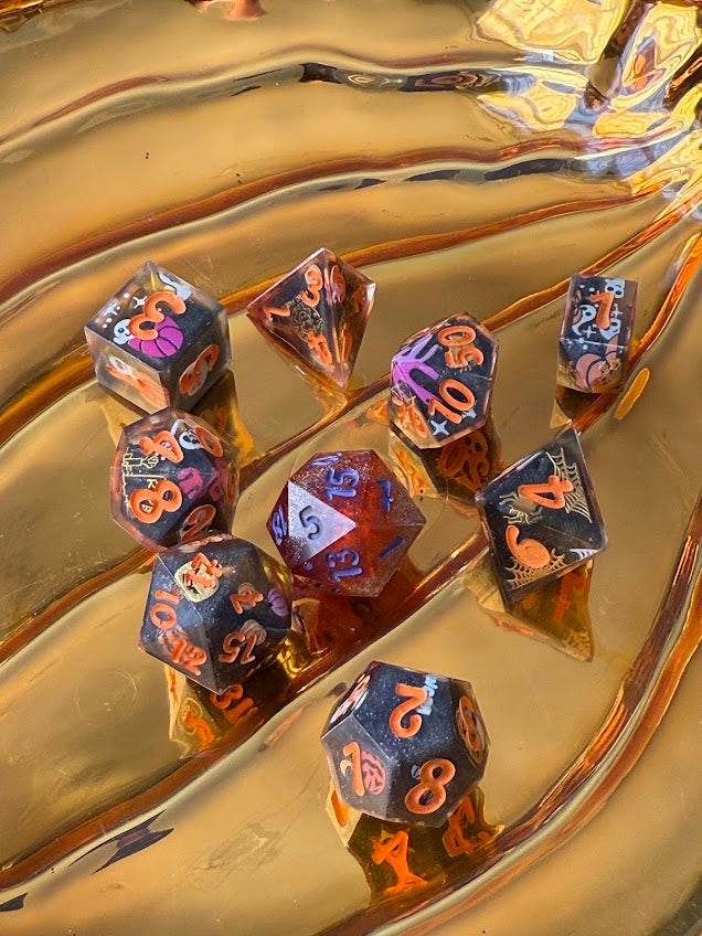 Set of dice with orange numbers on a reflective gold surface