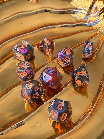 Set of dice with orange numbers on a reflective gold surface