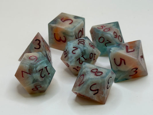 polyhedral sharp-edge, a set of seven in  red, green and bone white held in hands. Numbers are inked in red.