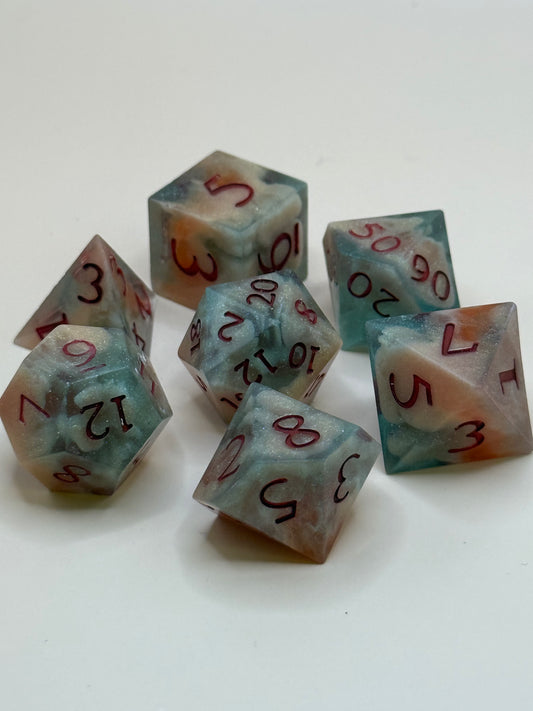 polyhedral sharp-edge, a set of seven in  red, green and bone white held in hands. Numbers are inked in red.