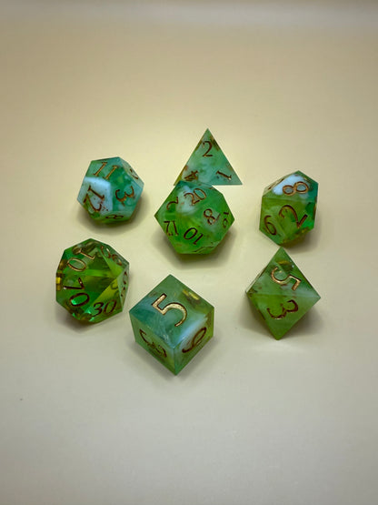 Set of green polyhedral dice with brown numbers on a beige background