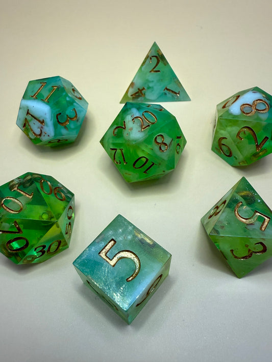 Set of green polyhedral dice with gold numbers on a white background