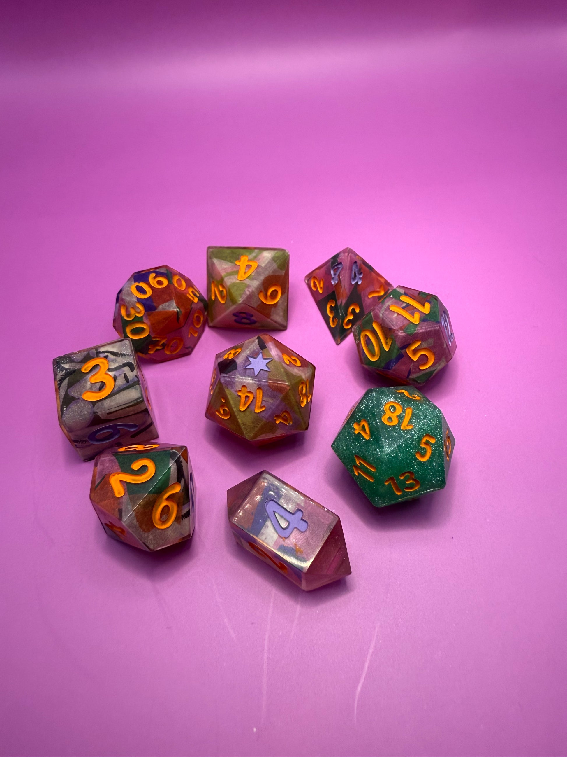 Set of colorful polyhedral dice on a pink background