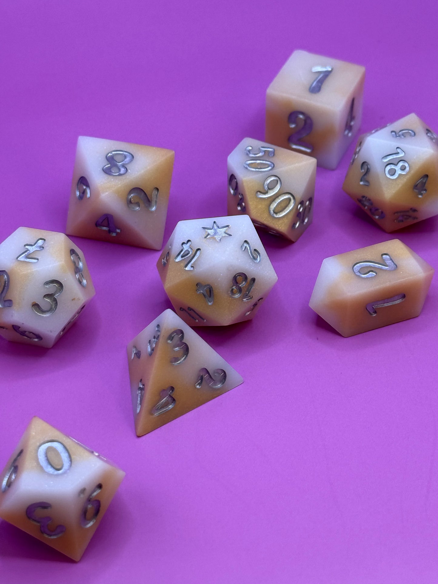 Set of polyhedral dice on a pink background