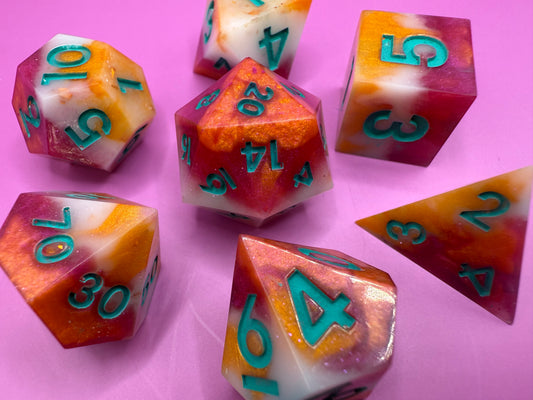 Colorful polyhedral dice with numbers on a pink background