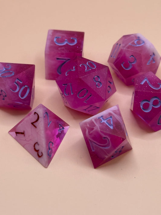 Set of pink and white polyhedral dice on a beige background