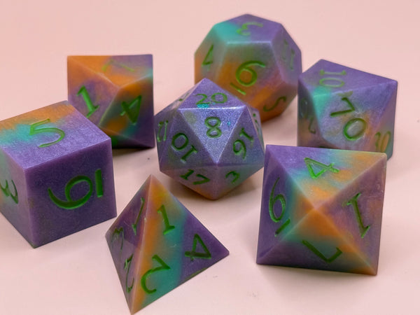 Colorful sharp-edged polyhedral resin dice set with purple, orange, and teal swirls