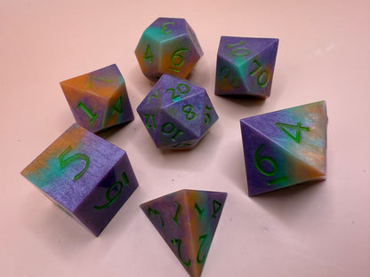 Set of colorful polyhedral dice with numbers on a light pink background