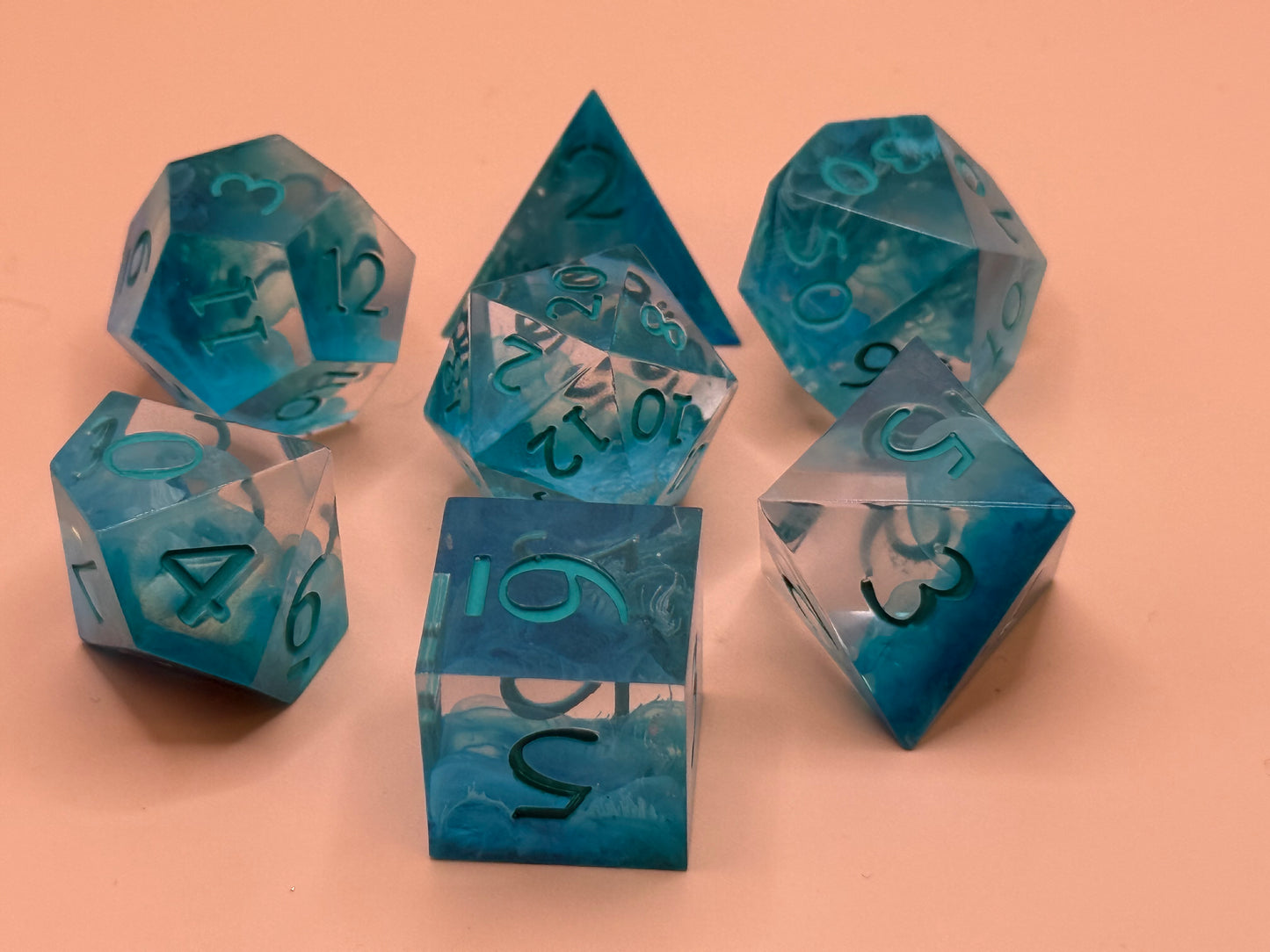 Set of blue polyhedral dice on a peach background