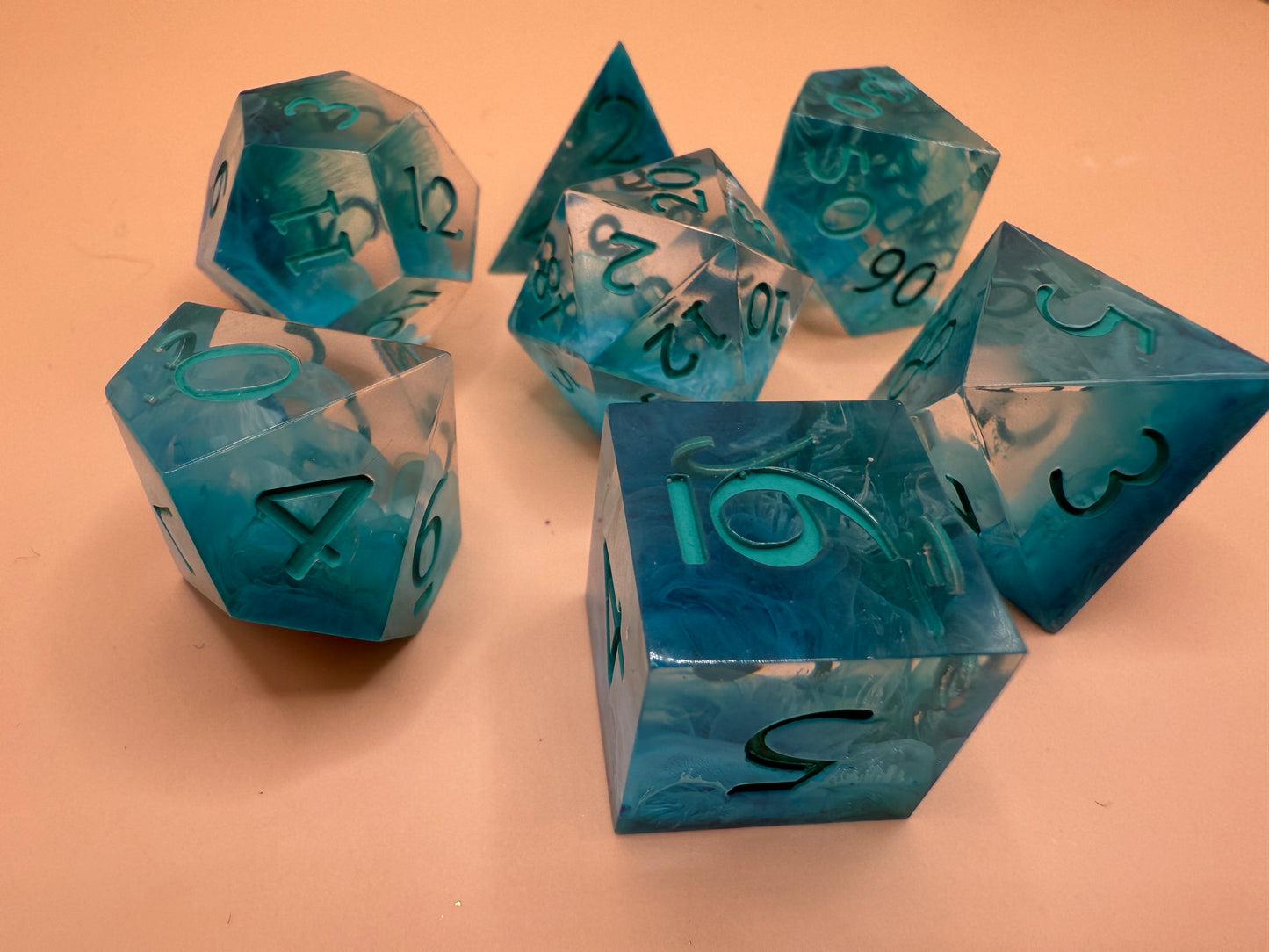 Set of blue polyhedral dice on a beige background