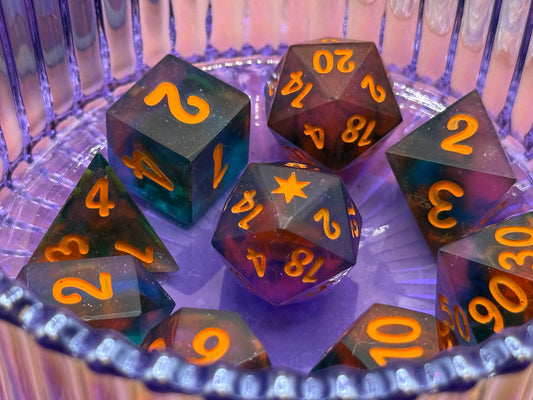 Set of polyhedral dice with orange numbers on a reflective surface