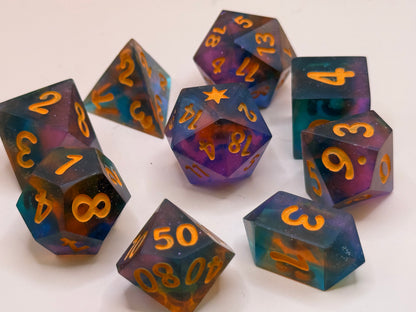 Set of colorful polyhedral dice with orange numbers on a white background