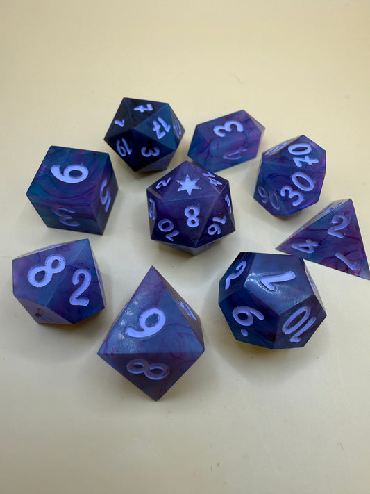 polyhedral sharp-edge, a set of seven in black, pink and purple held on a purple white. Numbers are inked in purple.