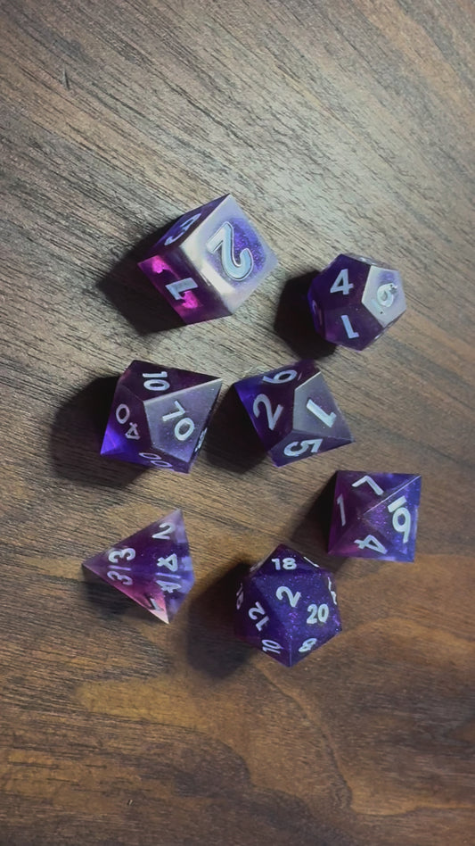 A video of polydactyl sharp-edge, a set of seven in blue and purple on a wood able. Numbers are inked in white.